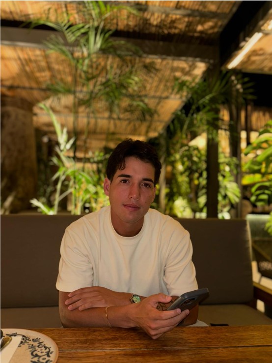 Alonso, fundador de AlonBets, sentado con el celular en la mano
